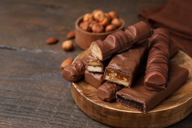 Photo of Different tasty chocolate bars on wooden table, closeup. Space for text