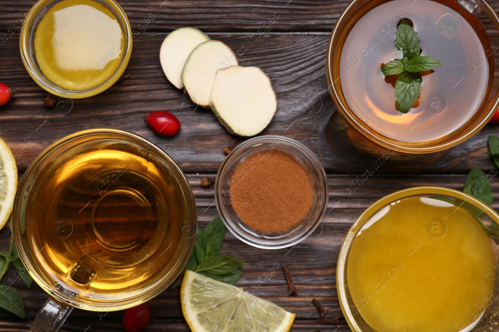 Photo of Flat lay composition of tea with honey and ingredients on wooden table