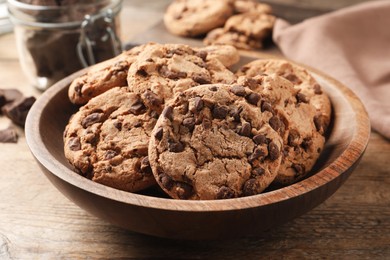Photo of Plate with delicious chocolate chip cookies on wooden table, closeup