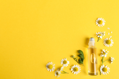 Photo of Flat lay composition with chamomile essential oil on yellow background. Space for text
