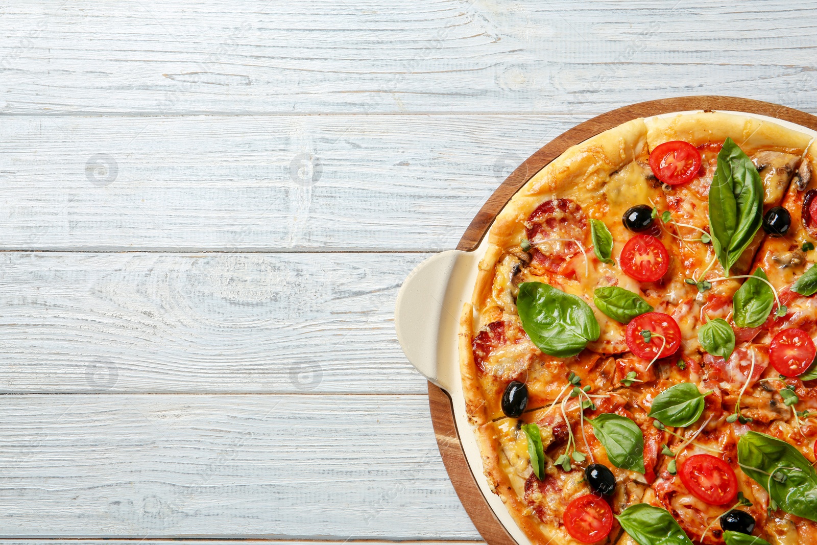 Photo of Tasty homemade pizza and space for text on wooden table, top view