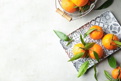 Flat lay composition with ripe tangerines on light background. Space for text