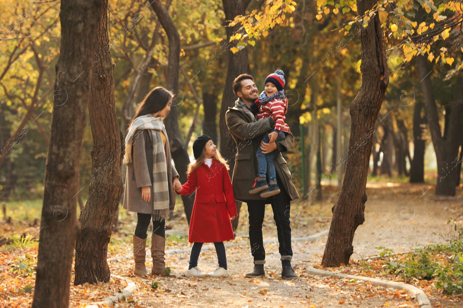 Photo of Happy family with children spending time together in park. Autumn walk