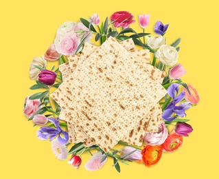 Image of Tasty matzos and flowers on yellow background, flat lay. Passover (Pesach) celebration