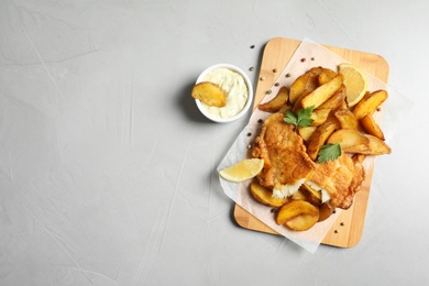 Photo of British traditional fish and potato chips on table, top view with space for text