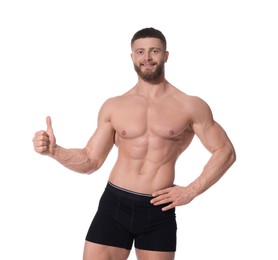 Photo of Young man is stylish black underwear showing thumb up on white background