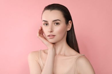 Portrait of beautiful young woman on pink background