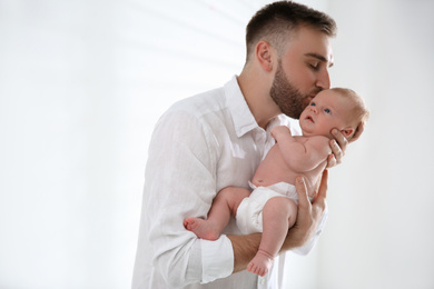 Photo of Father with his newborn son on light background