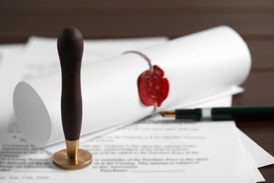 Notary contract. Documents, wax stamp and pen on table, closeup