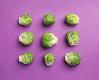 Fresh Brussels sprouts on purple background, flat lay