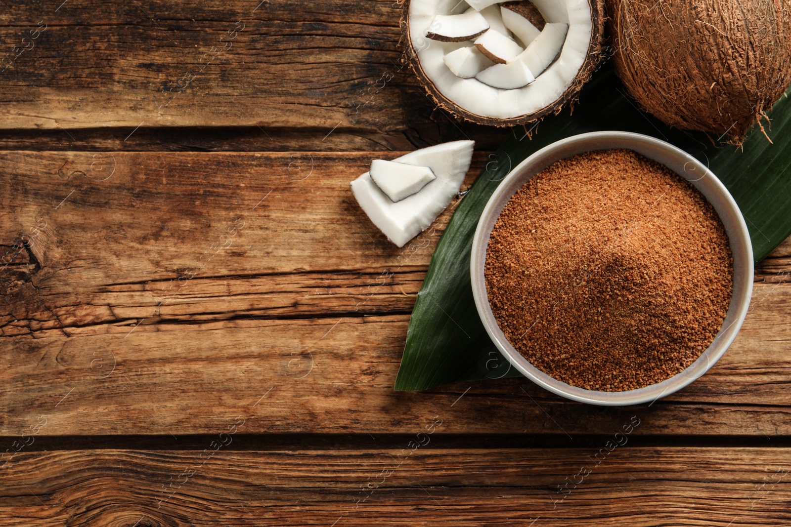 Photo of Flat lay composition with natural coconut sugar on wooden table, space for text