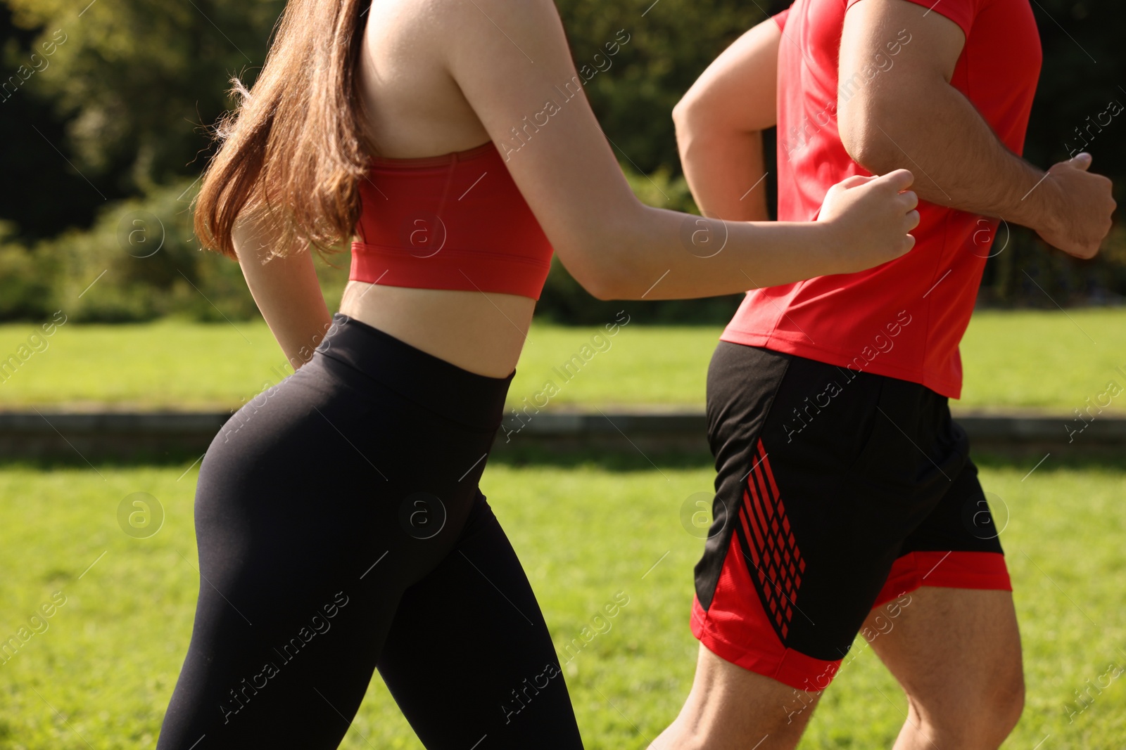 Photo of Healthy lifestyle. Couple running in park on sunny day, closeup