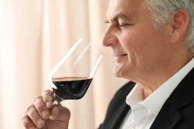 Photo of Senior man with glass of wine indoors