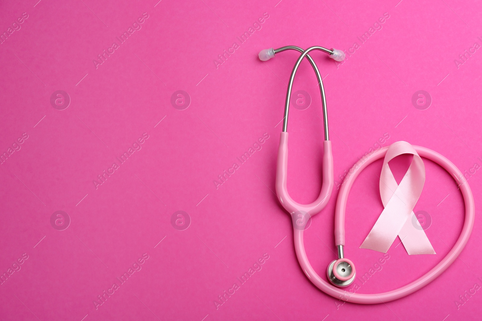 Photo of Pink ribbon and stethoscope on color background, flat lay with space for text. Breast cancer concept