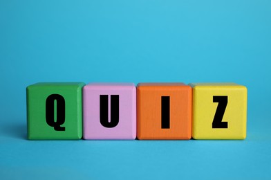 Photo of Colorful cubes with word Quiz on light blue background. Space for text