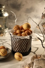 Photo of Aromatic walnut shaped cookies with tasty filling on beige table. Homemade pastry carrying festive atmosphere