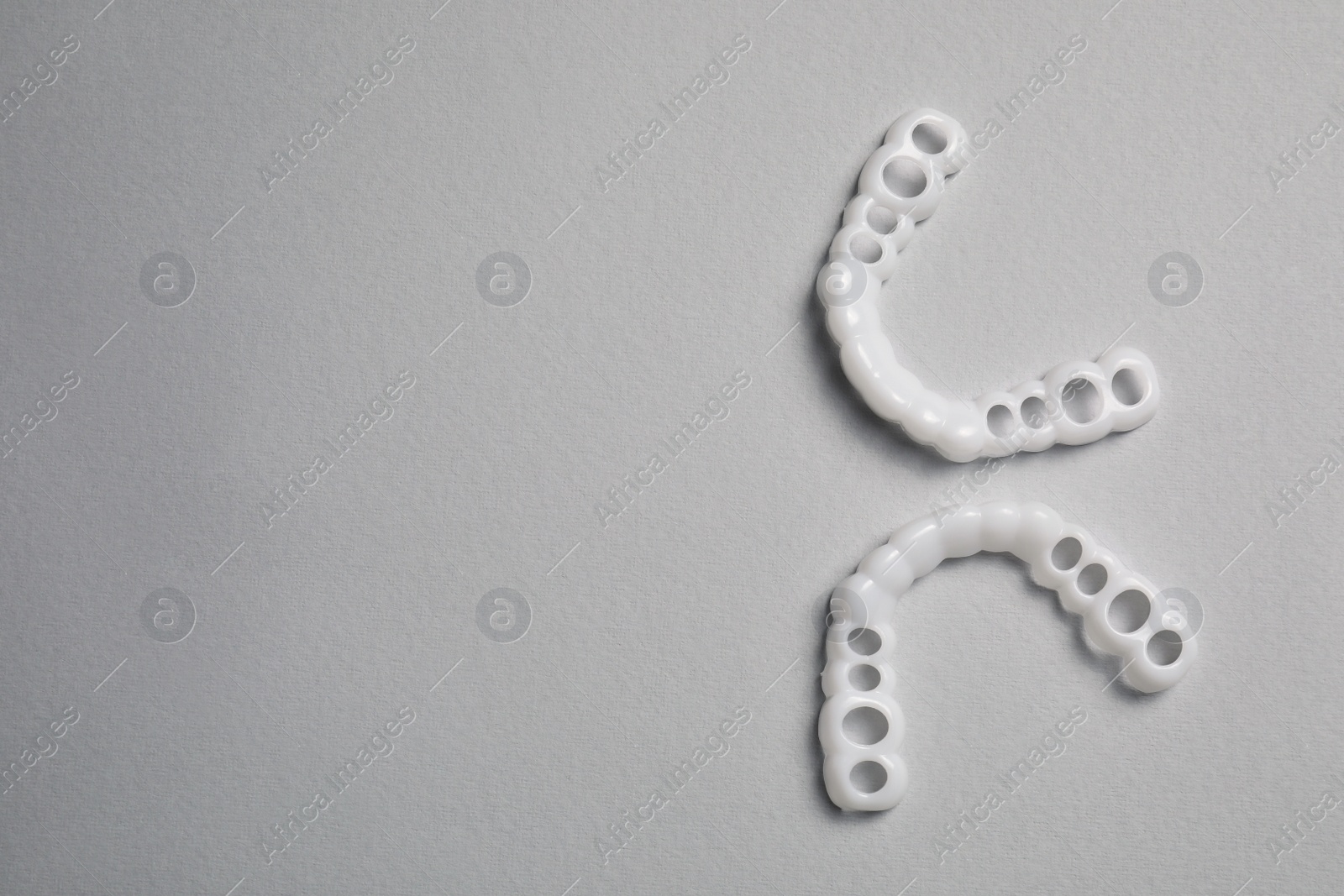 Photo of Dental mouth guards on light grey background, flat lay with space for text. Bite correction