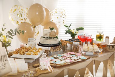 Baby shower party. Different delicious treats on wooden table and decor indoors