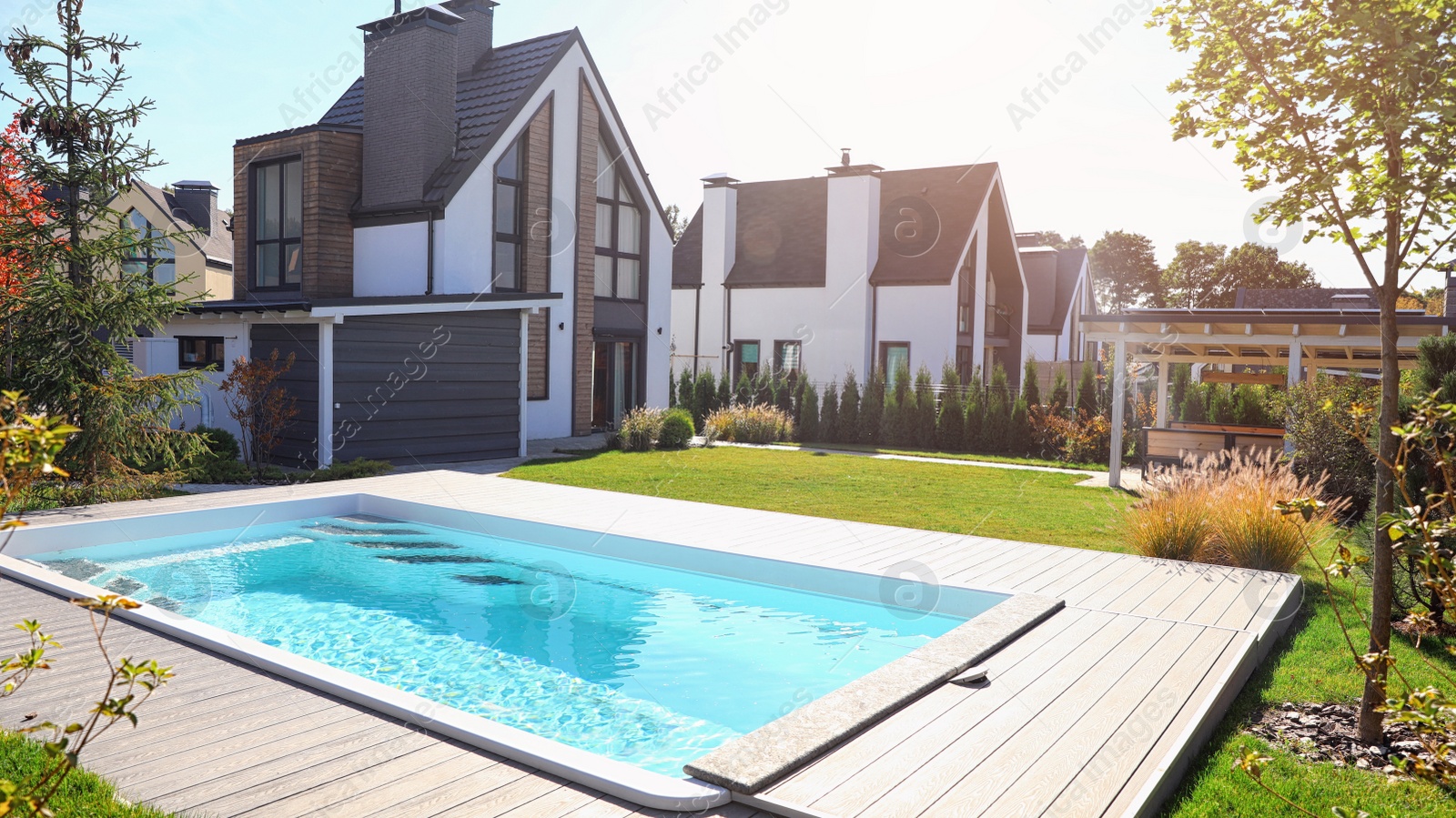 Photo of New modern house with backyard swimming pool on sunny day