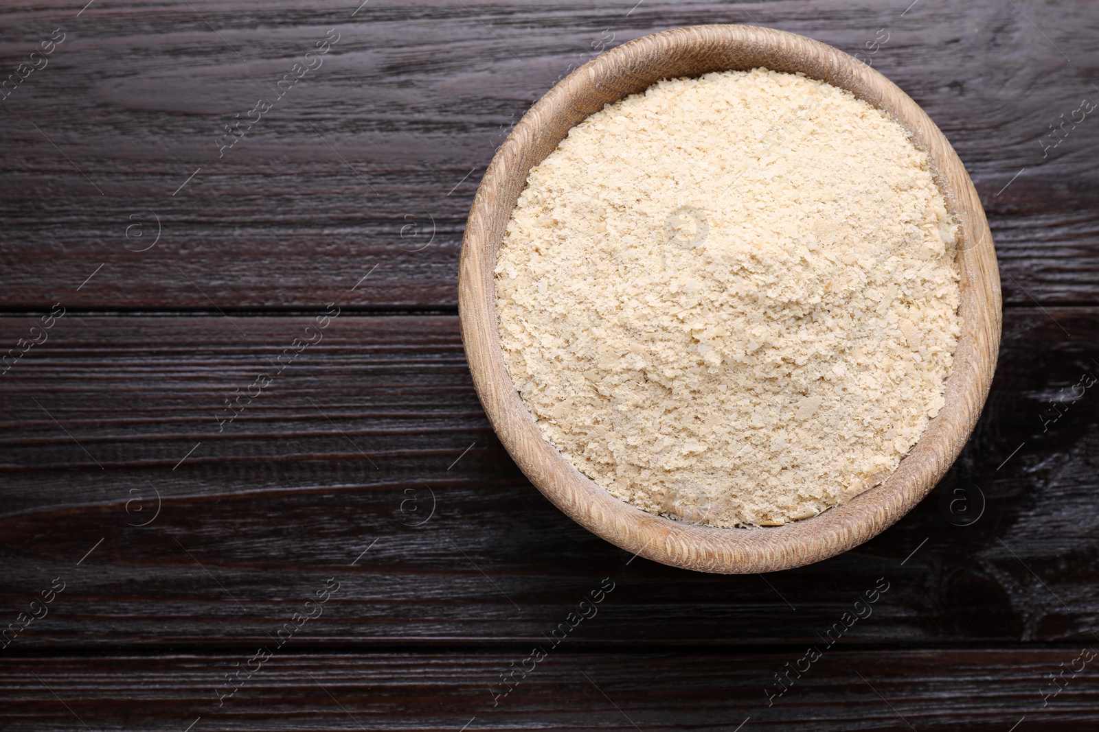 Photo of Beer yeast flakes on wooden table, top view. Space for text