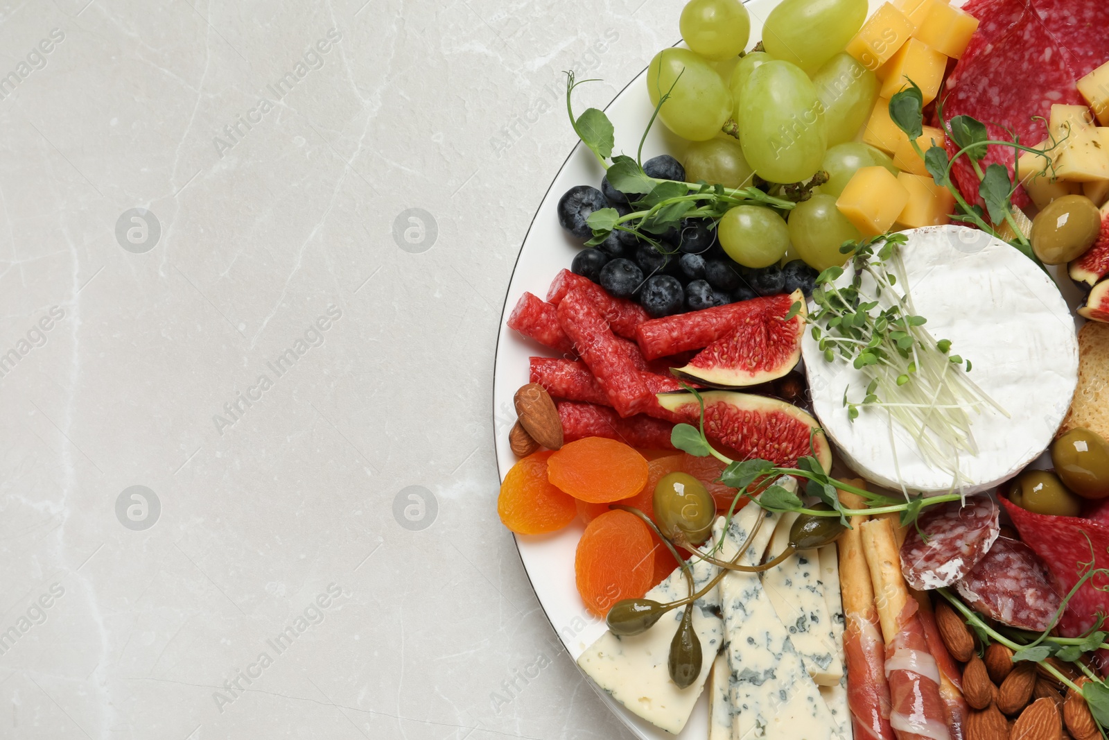 Photo of Set of different delicious appetizers served on light grey table, top view. Space for text