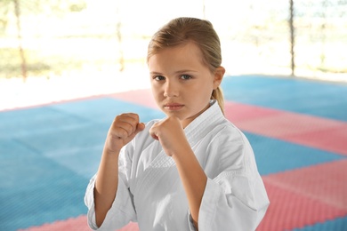 Photo of Girl in kimono practicing karate on tatami outdoors