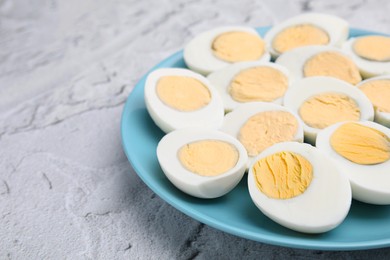 Photo of Fresh hard boiled eggs on light grey textured table. Space for text