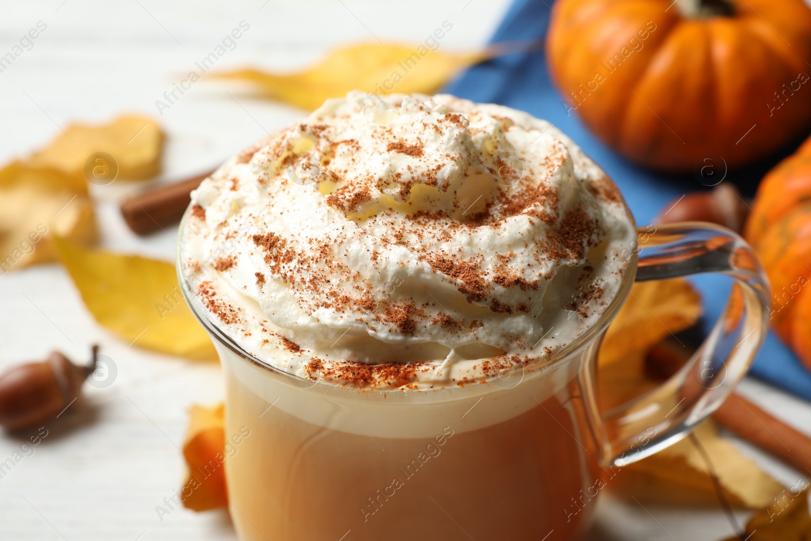 Photo of Delicious pumpkin latte on white table, closeup