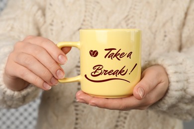 Image of Woman holding mug with inscription Take a Break, closeup