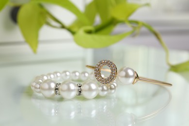 Photo of Elegant bracelets with pearls on white table, closeup