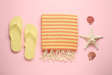 Photo of Beach towel and flip flops on pink background, flat lay