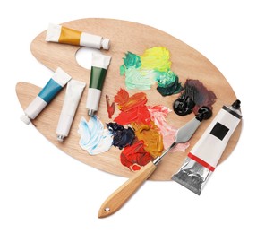 Photo of Wooden palette with oil paints and palette knife on white background, top view