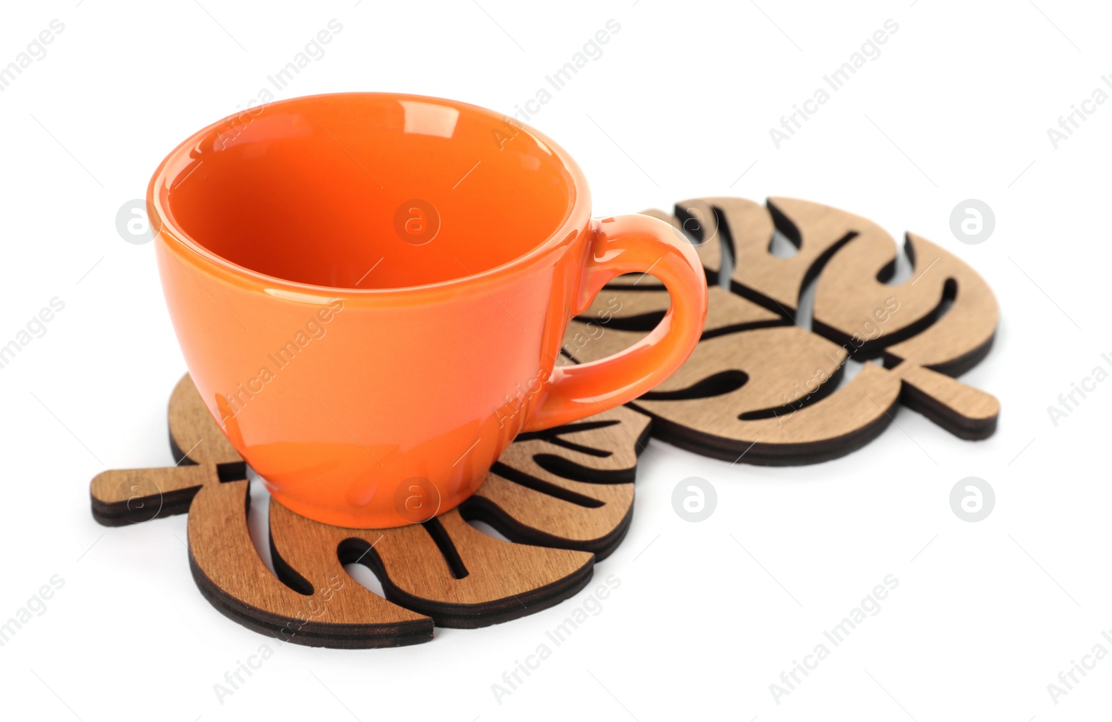 Photo of Leaf shaped wooden coasters and cup on white background