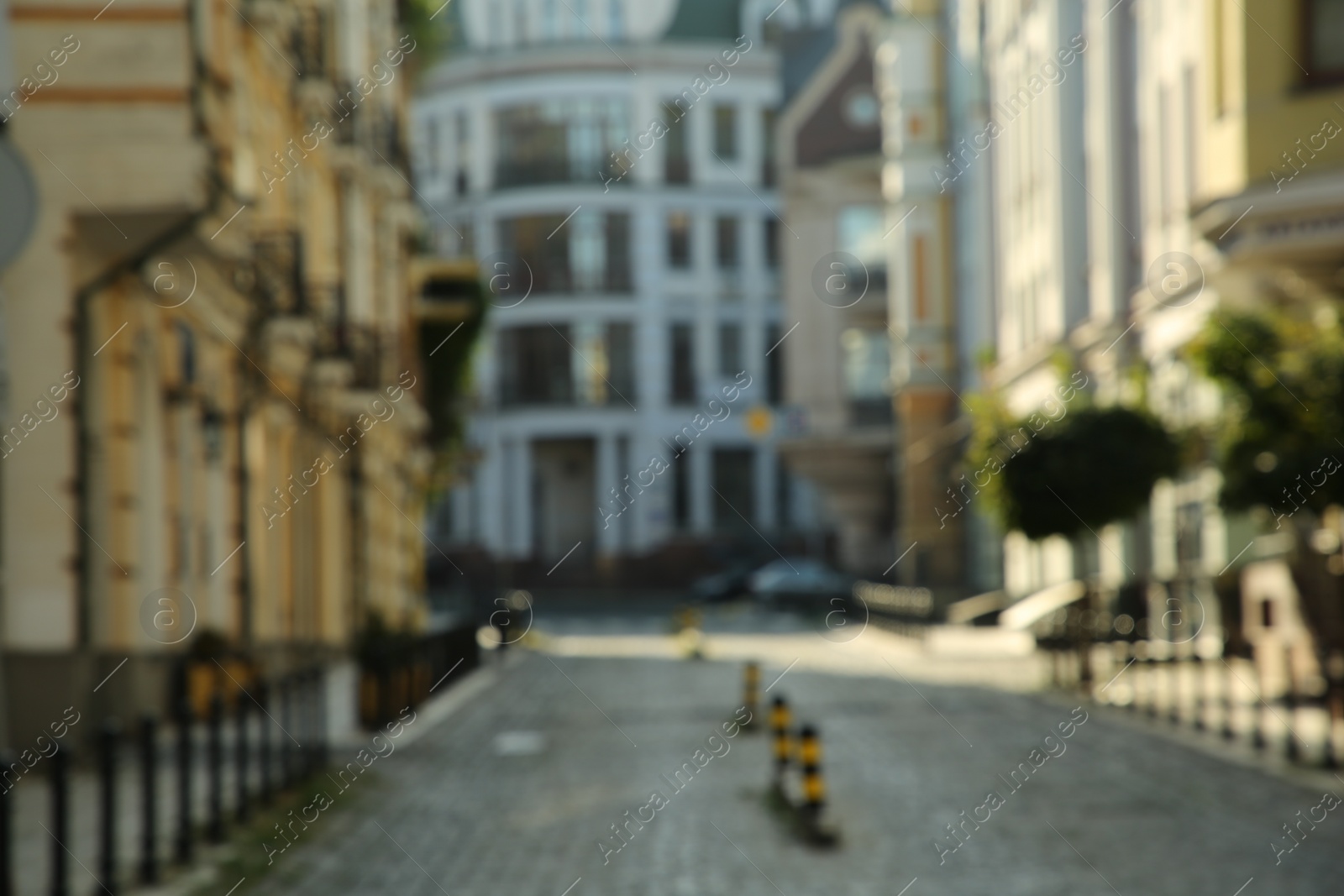 Photo of Blurred view of quiet city street with buildings on sunny day