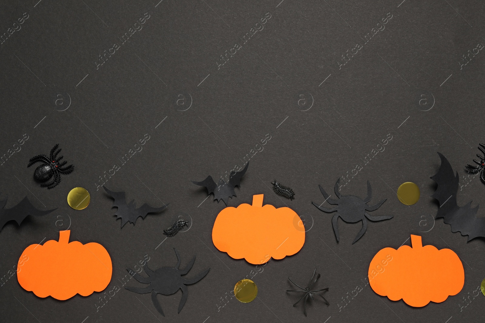 Photo of Flat lay composition with paper bats, pumpkins and spiders on black background, space for text. Halloween decor