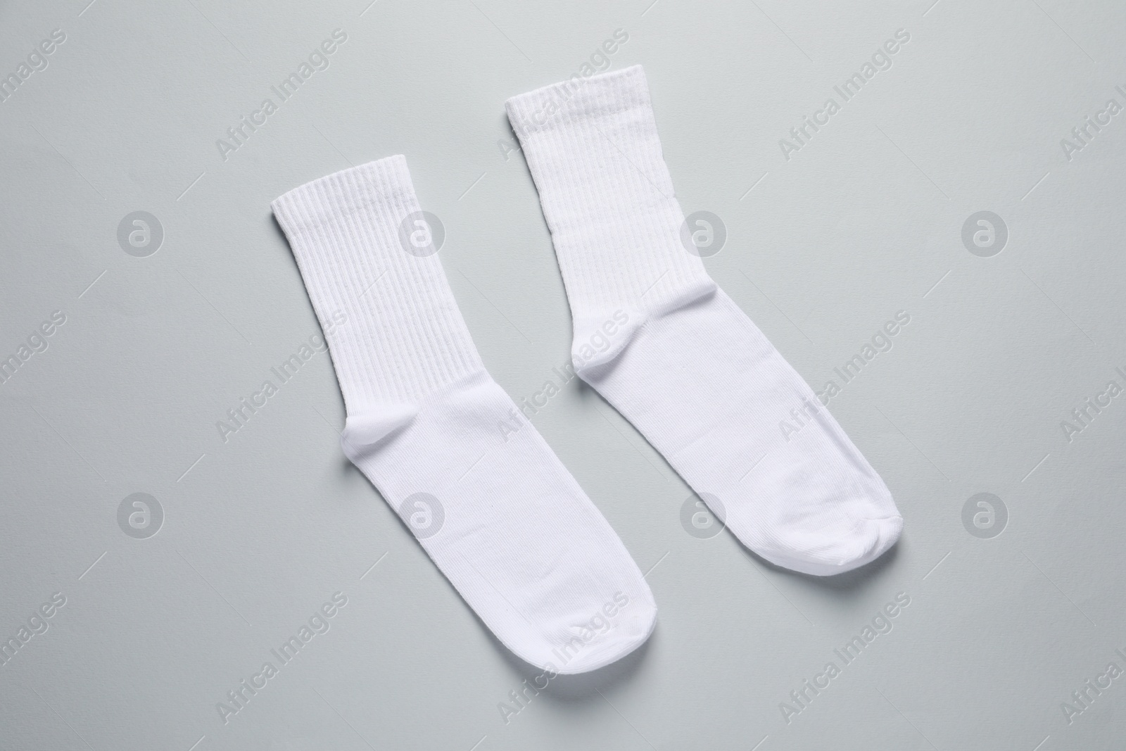 Photo of Pair of white socks on light grey background, flat lay