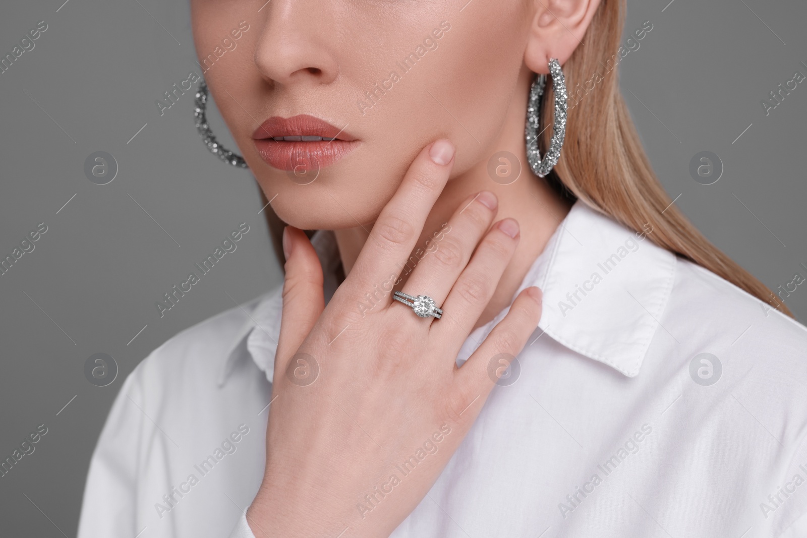 Photo of Woman with elegant jewelry on gray background, closeup