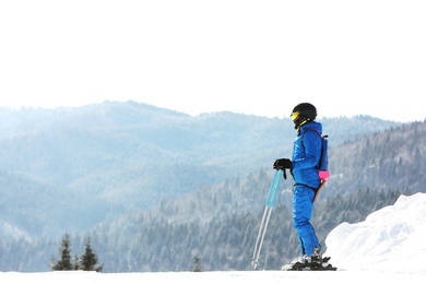 Photo of Man skiing on snowy hill in mountains, space for text. Winter vacation