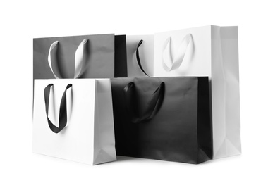 Photo of Paper shopping bags with ribbon handles on white background. Mockup for design