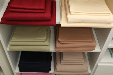 Photo of Different colorful bed linens on display in shop, above view
