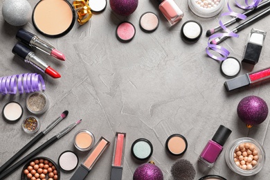 Photo of Flat lay composition with makeup products and Christmas decor on gray background. Space for text