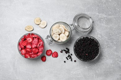Photo of Many different freeze dried fruits on light grey table, flat lay