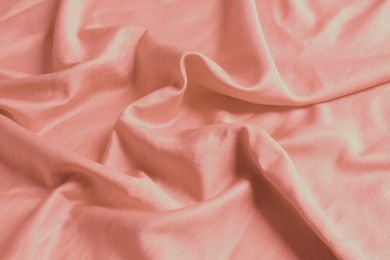 Photo of Pink shiny fabric as background, closeup view