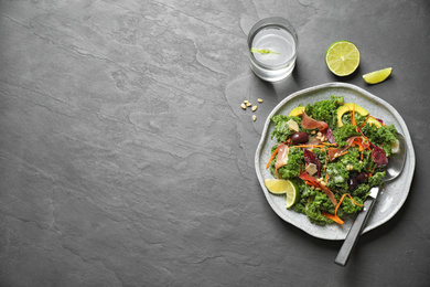 Photo of Tasty fresh kale salad on black table, flat lay. Space for text