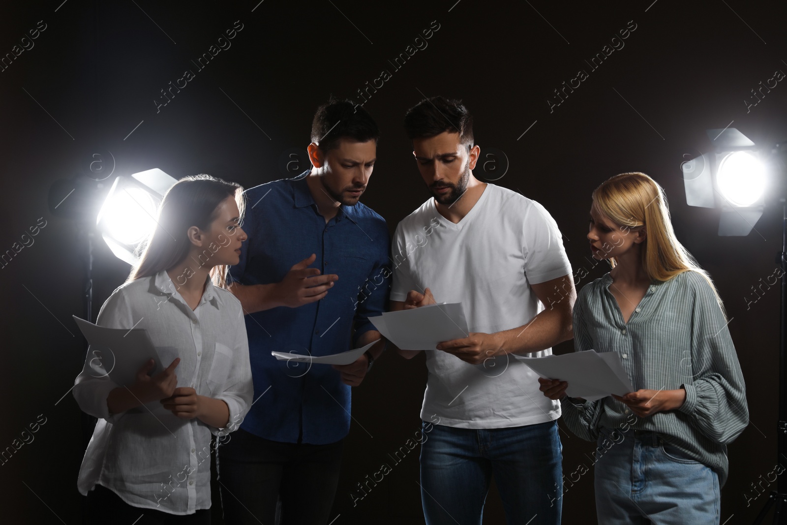 Photo of Professional actors reading their scripts during rehearsal in theatre