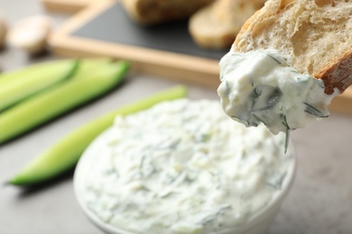 Photo of Bread in cucumber sauce on blurred background, space for text. Traditional Tzatziki