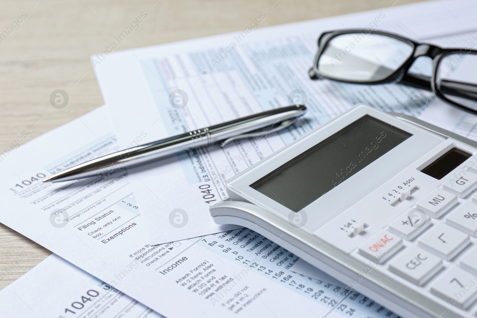Photo of Calculator, documents, glasses and pen on wooden table, closeup. Tax accounting