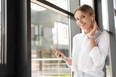 Photo of Portrait of female business trainer with smartphone indoors