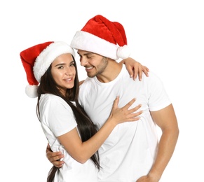 Young happy couple with Santa hats on white background. Christmas celebration