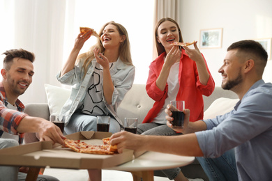 Group of friends eating tasty pizza at home